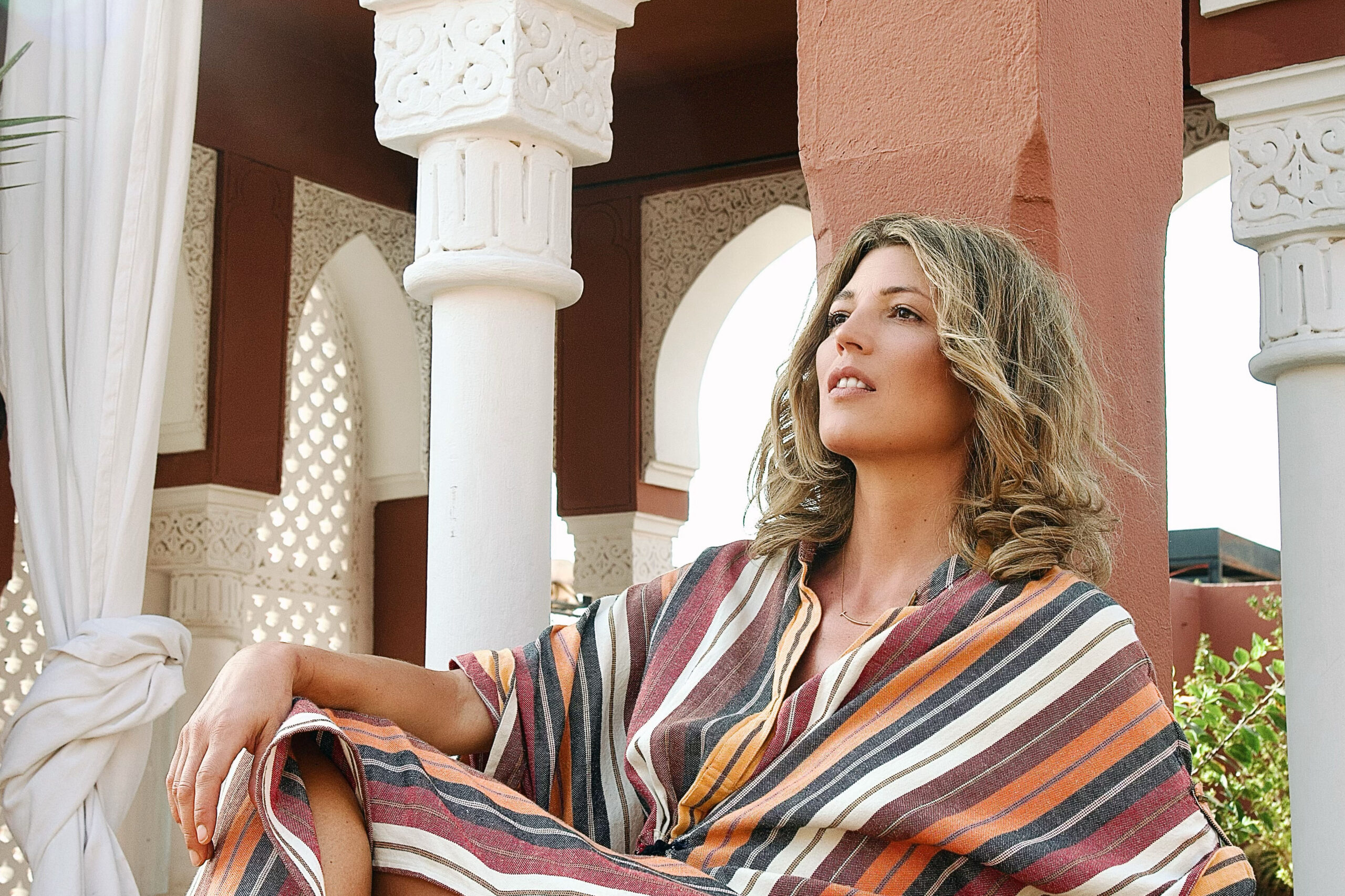 Tanja Gacic reclining on the rooftop of Riad Kaiss in Marrakech wearing a stripped Ilio Nema Dress